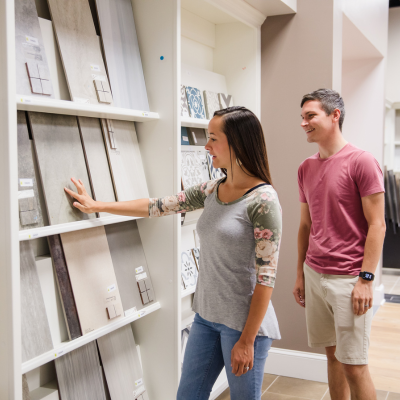 Homeowners comparing decorative tile and backsplash samples in the Greer Flooring Center showroom